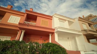 Lüks şehir bloğunda sütunları ve terasları olan Kızıl Akdeniz evi. Şehir merkezindeki konut kompleksinde renkli bir apartman. Dış tasarım