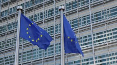 BRÜKSEL, BELGIUM - 27 Eylül 2025: Avrupa Birliği mavi bayrakları Berlaymont bina cephesine karşı rüzgarda dalgalanıyor. Avrupa Komisyonu karargahı yakınlarında demokrasi sembolleri