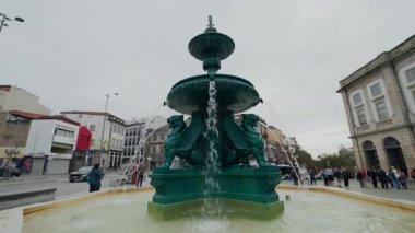PORTO, PORTUGAL - 22 Ekim 2025: Aslanların Çeşmesi Avrupa 'da berrak su spreyleri ve yürüyen turistler. Eski şehir meydanındaki kentsel kültürü temsil eden antik mimari simgeler