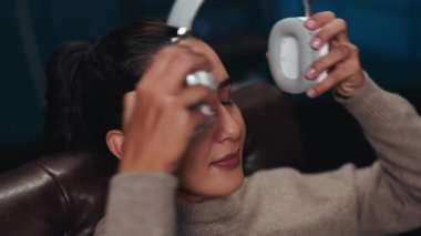 Gözleri kapalı rüya gören kadın portresi evde kulaklık takıyor. Genç bir bayan oturma odasında en sevdiği parçaları dinler. Ses terapisi oturumu