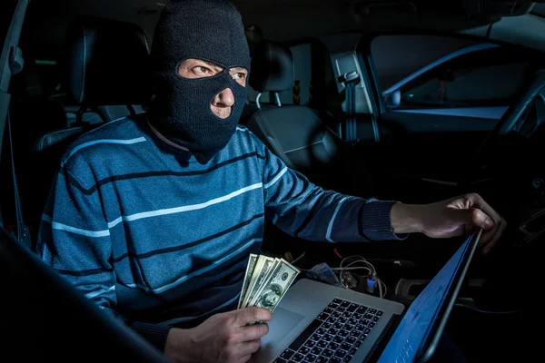 Hacker mit Maske und Laptop im Auto — Stockbild Hacker mit Laptop im Auto — Stockfoto