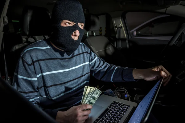 Hacker com um laptop dentro de um carro — Fotografia de Stock