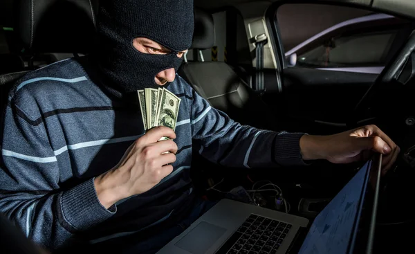 Hacker com um laptop dentro de um carro — Fotografia de Stock