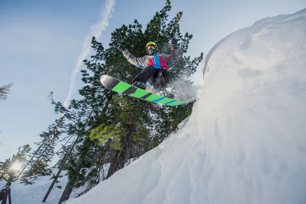 Vliegende snowboarder in de bergen — Stockfoto