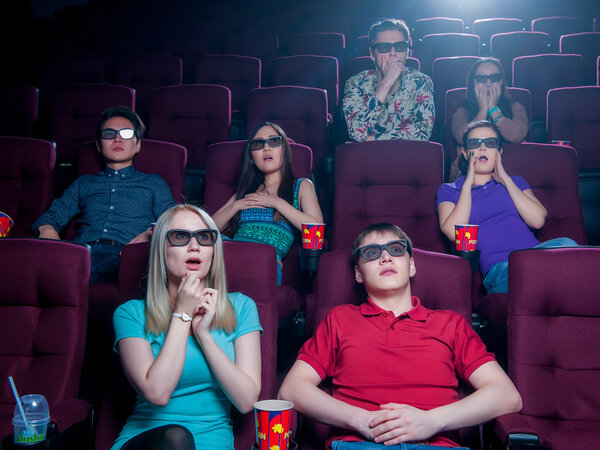 Люди в кинотеатре в 3D очках
