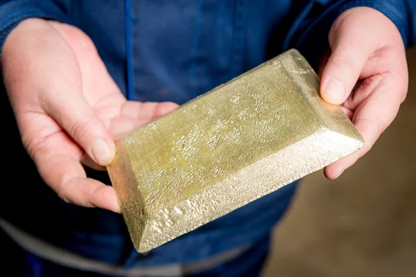 Raw gold ingot in the hands — Stock Photo, Image