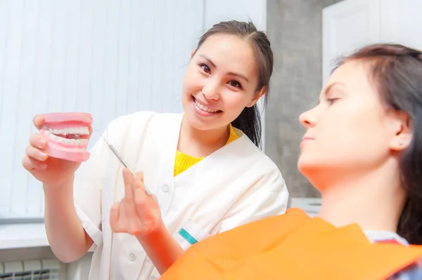 Dentista mostrar dentaduras postizas a un paciente — Foto de Stock