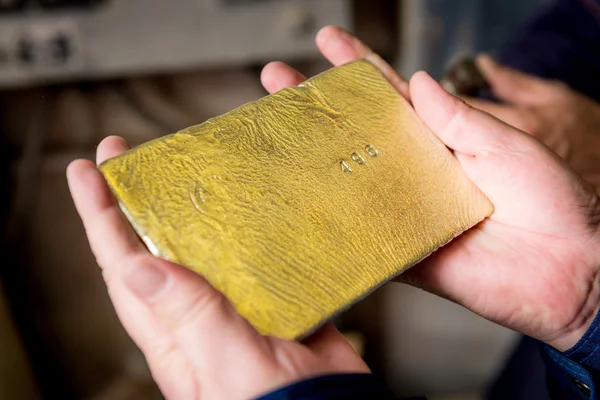 Raw gold ingot in the hands — Stock Photo, Image