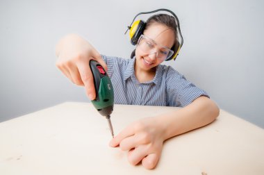 Elinde matkapla genç bir kadın