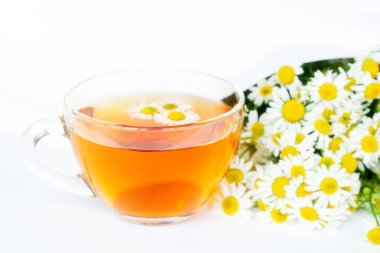 Beyaz arka plan doktoru tedavisi ve bağışıklık konsepti, ilaç - halk, alternatif, tamamlayıcı, geleneksel tıp üzerine bir fincan papatya çayı ve papatya çiçeği.