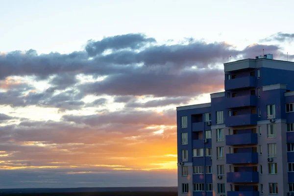 云彩和橙色的夕阳西下 是一座高层住宅建筑的侧景 落日风暴天上方的建筑工地 灰白色滤光片 — 图库照片
