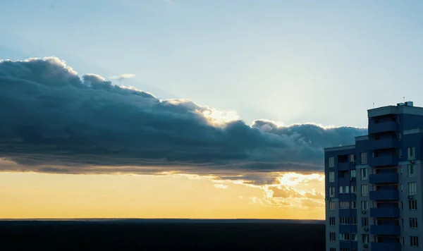 云彩和橙色的夕阳西下 是一座高层住宅建筑的侧景 落日风暴天上方的建筑工地 灰白色滤光片 — 图库照片