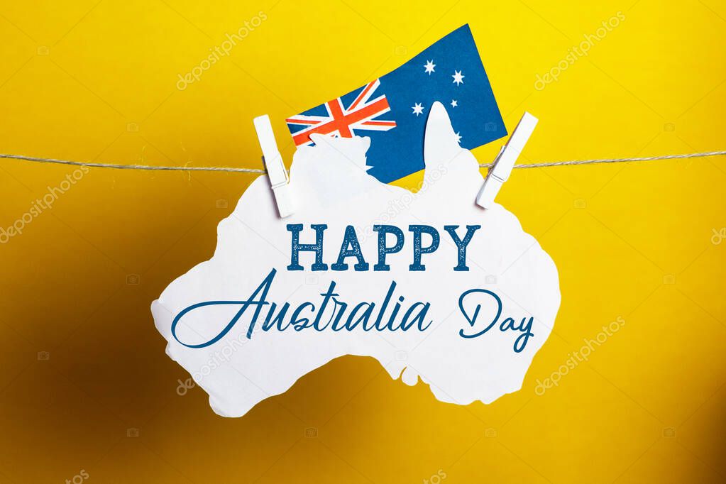 Happy Australia Day message greeting written card across Australian maps and flag hanging pegs , Celebrate Australia-Day holiday on January 26