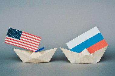 paper ship with Flags of USA and Russia. conflict,  shipment or free trade agreement and membership concept