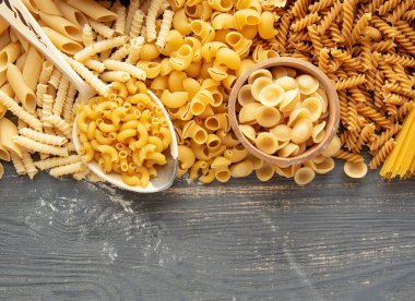 Çeşitli türlerde ve şekillerde çiğ İtalyan makarnası ve spagetti - geleneksel İtalyan yemeği arka planı