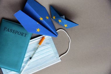 Tıbbi maske, pasaport, aşı, Avrupa Birliği bayrağındaki kağıt uçak - Coronavirus konsepti COVID aşı pasaportu, yeni uçuş yasağı seyahat, havacılık işi