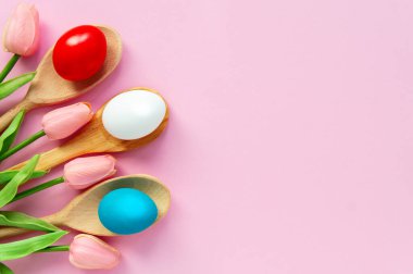 Paskalya tatiliniz kutlu olsun, Paskalya yumurtaları pembe arka planda mavi, beyaz, kırmızı renkler.