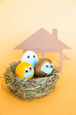  Tıbbi yüz maskeli parlak renkli Paskalya yumurtaları ev karantinası sırasında dini bayramları kutluyor, Coronavirus covid 19 Pandemik