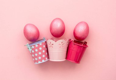 Paskalya arkaplanı bej arka planda pembe renkli yumurtalar.