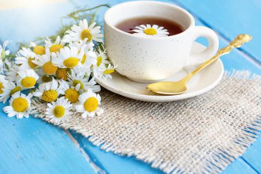  Bir fincan papatya çayı ve taze papatya çiçeği arkaplanı, tedavi ve bağışıklık konsepti, ilaç