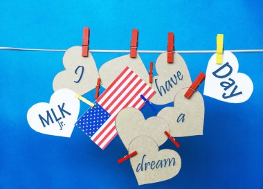 White  hearts - room for text,  USA ( America) flag hanging on colorful pegs ( clothespin ) on a line against a blue background.  United States of America.  Concept - Martin Luther King Day January 18. I have a dream collage. clipart