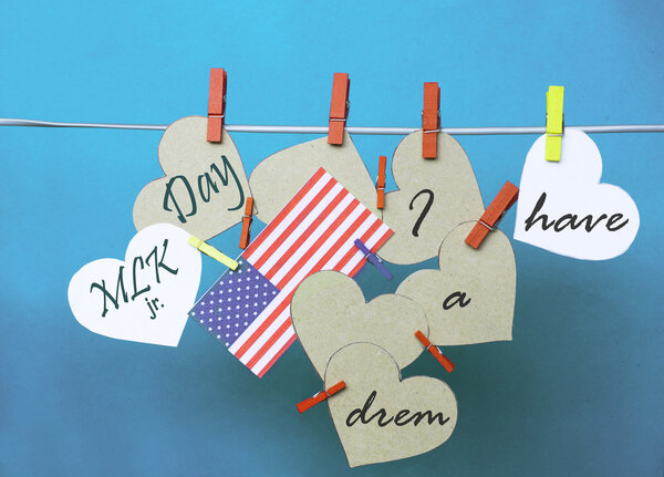 White  hearts - room for text,  USA ( America) flag hanging on colorful pegs ( clothespin ) on a line against a blue background.  United States of America.  Concept - Martin Luther King Day January 18. I have a dream collage.