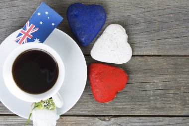 Heart shaped cookies red, white, blue.  cup of coffee (tea), Australia flag - decoration on old wooden table. notebook Happy Australia Day and koala. Sunny morning. Toned colored