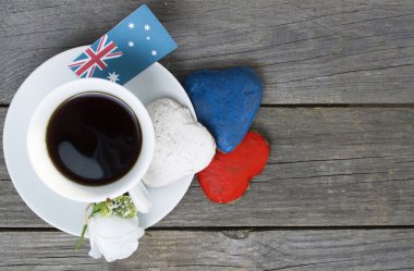 Heart shaped cookies red, white, blue.  cup of coffee (tea), Australia flag - decoration on old wooden table. notebook Happy Australia Day and koala. Sunny morning. Toned colored