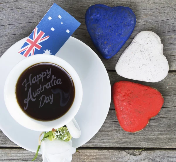 Heart shaped cookies red, white, blue.  cup of coffee (tea), Australia flag - decoration on old wooden table. notebook Happy Australia Day and koala. Sunny morning. Toned colored