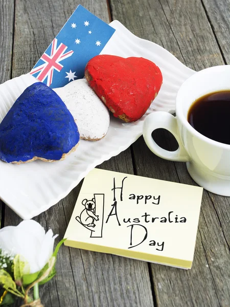 Galletas en forma de corazón rojo, blanco, azul. taza de café (té), bandera de Australia - decoración en la vieja mesa de madera. cuaderno Feliz Día de Australia y koala. Mañana soleada. Tonificado de color — Foto de Stock