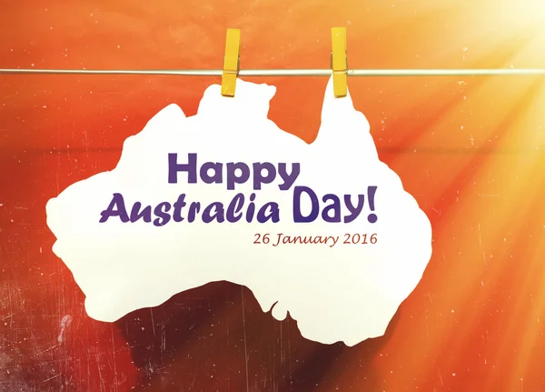 Celebrate Australia Day holiday on January 26 2016 with a Happy Australia Day message greeting written across white Australian maps (red heart) and flag hanging pegs on blue. — 图库照片