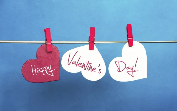 White and Red hearts on clothespins hanging  on blue background. — Stock Photo, Image