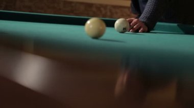 Bardaki adam bilardo oynuyor. Adamın biri bilardo topuna ıstakayla vuruyor ve top deliğe düşüyor.