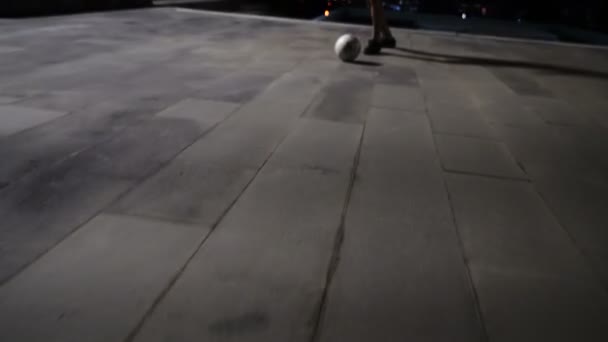 一个晚上在城市背景下踢足球的男人的轮廓 — 图库视频影像
