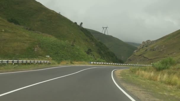 Samochód Jedzie Płaską Asfaltową Drogą Między Jeziorem Zielonymi Wzgórzami Lasami — Wideo stockowe