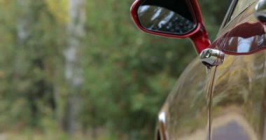 Adam kapıyı açıyor ve arabadan iniyor. Erkek işadamının eli arabanın kapısını açar.. 