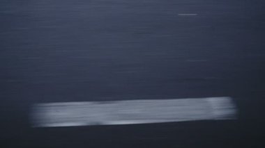 Araba hareket ederken asfaltta beyaz izler var.