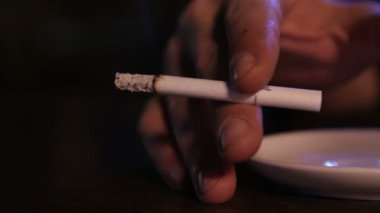 Yanan bir sigaradan çıkan duman. Yanan bir sigarayı tutan adamın eli. - Kapat.