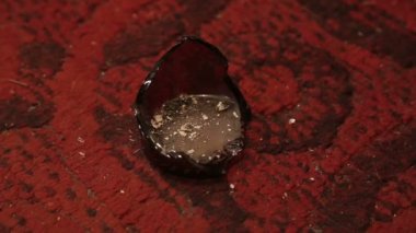 Adam sigara küllerini kırık bir şişeye boşaltıyor.