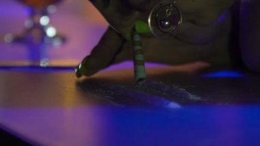 Bardaki striptizci kız kokain kuyruklarını bir dolarla kokluyor.