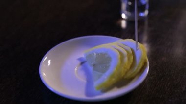 Adam votka içip limon yiyor.