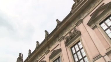 Berlin 'de taş heykelleri olan güzel bir binanın manzarası.