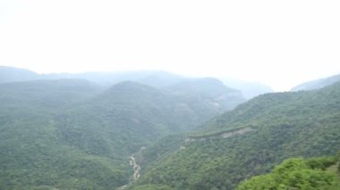 Panoramik dağlar yaz mevsiminde yeşil ormanı tepeden görüyor.