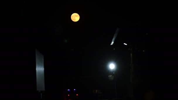 Wielki Pomarańczowy Księżyc Głębokiej Nocy Wielokolorowe Błyski Radiowozu Stojącego Przy — Wideo stockowe