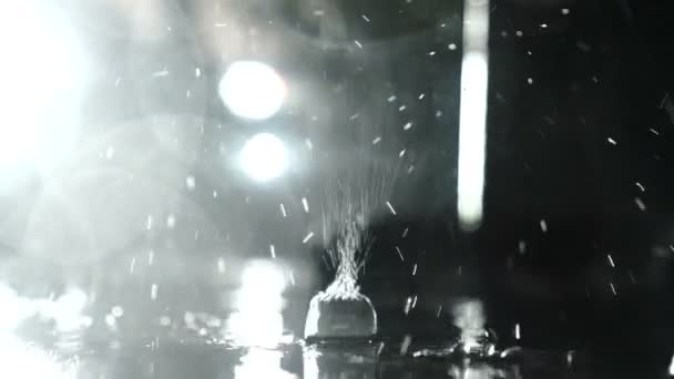 雨は暗闇の中で水たまりにぶつかる — ストック動画