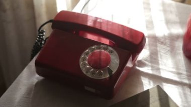 Kırmızı bir Rotary arama telefonu çalıyor. Eski usul bir telefondan arıyorum. Kırmızı antika telefon. Retro telefon susmak bilmedi. Eski telefonlara cevap vermek, konuşmak, sohbet etmek..