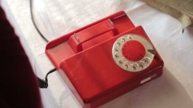 Kırmızı bir Rotary arama telefonu çalıyor. Eski usul bir telefondan arıyorum. Kırmızı antika telefon. Retro telefon susmak bilmedi. Eski telefonlara cevap vermek, konuşmak, sohbet etmek..