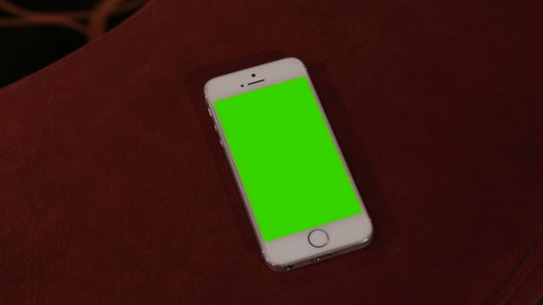 顶部视图 智能电话放在带有绿色屏风的桌材上 闭路电话放在带有色键的褐色桌面上 绿色屏风电话 — 图库视频影像