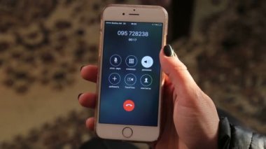 Bir adam, bir kadın akıllı telefonu elinde tutuyor ve hoparlörden konuşuyor. Telefonlu bir elin yakın çekimi. Evden ara. Akıllı telefonu kulağına dayar ve telefonda konuşmaya başlar..