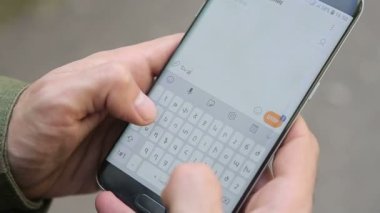Cep telefonuna bir mesaj yazar. Telefon onun elinde..  